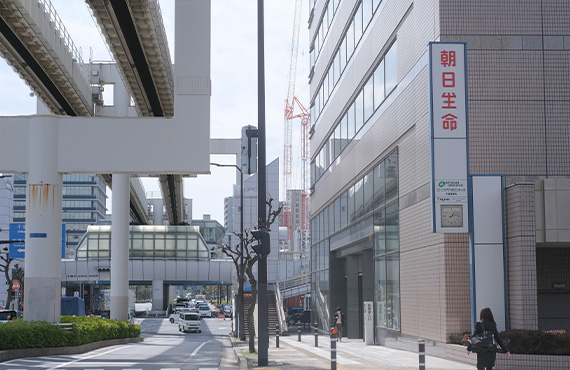 上空に千葉都市モノレール線路がある道を進むと朝日生命の看板が見えてきますので、そこを右に曲がります。
